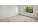 An empty bedroom features neutral carpet and a window with view to the outside at 101 N Grandview St # 103, Mount Dora, FL 32757