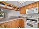 Kitchen features a half wall to the living room and white appliances paired with light wood cabinetry at 101 N Grandview St # 103, Mount Dora, FL 32757