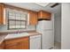 Traditional kitchen with a white double basin sink, dishwasher, and refrigerator next to oak cabinets at 101 N Grandview St # 103, Mount Dora, FL 32757