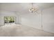 Spacious living room with neutral carpet, ceiling fan, and sliding glass doors leading to the outside at 101 N Grandview St # 103, Mount Dora, FL 32757