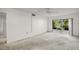 Living room featuring neutral carpet, ceiling fan, and sliding glass doors leading to a screened in porch at 101 N Grandview St # 103, Mount Dora, FL 32757