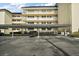 Photo showcases covered parking, with support posts and black motorcycle in front of white condo buildings at 101 N Grandview St # 103, Mount Dora, FL 32757