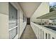 Exterior walkway featuring a white railing, screened door, leading to covered parking and more condos at 101 N Grandview St # 103, Mount Dora, FL 32757
