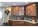 Galley-style kitchen featuring wood cabinets and mosaic backsplash at 1041 Reidville Rd, The Villages, FL 32162