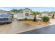 Charming single-story home featuring a well-manicured lawn, beautiful landscaping, and a two-car garage at 1065 Berg Ct, The Villages, FL 32162