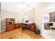 Comfortable home office includes built-in bookshelves, hard floors, and adjacent partial view of kitchen at 1065 Berg Ct, The Villages, FL 32162