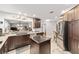 Open kitchen with dark cabinetry, stainless steel appliances, a central island, and a breakfast bar overlooking the living area at 1065 Berg Ct, The Villages, FL 32162