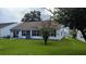 Expansive backyard featuring a table setting, grill, and lush green lawn at 1105 San Remo Ln, Lady Lake, FL 32159