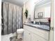Bathroom featuring a shower, toilet, vanity, mirror, and gray marble sink top at 1105 San Remo Ln, Lady Lake, FL 32159