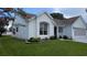 Charming home featuring a well-manicured lawn and flower beds with various plants at 1105 San Remo Ln, Lady Lake, FL 32159