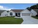 Charming home featuring a well-manicured lawn and a convenient two-car garage at 1105 San Remo Ln, Lady Lake, FL 32159