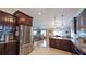 Open-concept kitchen with wood cabinets, granite counters and stainless refrigerator adjacent to living area at 1105 San Remo Ln, Lady Lake, FL 32159