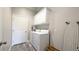 Bright laundry room with washer, dryer, white cabinets for storage, and gray flooring at 1105 San Remo Ln, Lady Lake, FL 32159