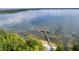 Scenic aerial view of a lake and private boat dock, with lush green trees at 11926 Milan Way, Leesburg, FL 34788
