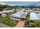 Community aerial view with well-maintained homes, covered carports, Florida rooms, and landscaping at 11926 Milan Way, Leesburg, FL 34788
