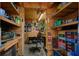 Organized shed interior with shelving, desk, work area, and whimsical art on the walls at 11926 Milan Way, Leesburg, FL 34788