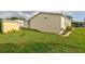 Side yard view showing the home's vinyl siding and tidy lawn area with landscape edging at 11926 Milan Way, Leesburg, FL 34788