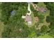 Aerial view showcasing a pool and lush landscaping surrounded by greenery and a winding driveway at 1325 Otters View Ct, Fruitland Park, FL 34731