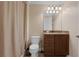 Cozy bathroom with a vanity, granite countertop, framed mirror, decorative lighting, and toilet at 1325 Otters View Ct, Fruitland Park, FL 34731