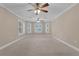 Spacious carpeted bedroom offering natural light from bright windows and a ceiling fan with lights at 1325 Otters View Ct, Fruitland Park, FL 34731