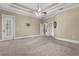 Expansive bedroom features ceiling fan, tray ceiling, and entry to other rooms at 1325 Otters View Ct, Fruitland Park, FL 34731