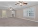 Generous bedroom with neutral carpet, bright windows, and an open doorway to another living area at 1325 Otters View Ct, Fruitland Park, FL 34731