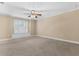 Bright and airy bedroom featuring neutral carpet, recessed lighting and a large window with shutters at 1325 Otters View Ct, Fruitland Park, FL 34731