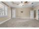 Large bedroom with fan, tray ceiling, and access to bathroom and patio at 1325 Otters View Ct, Fruitland Park, FL 34731