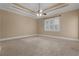 Spacious bedroom with neutral carpet, fan, and tray ceiling detail at 1325 Otters View Ct, Fruitland Park, FL 34731