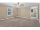 Bright bedroom features neutral carpet, bright windows, and an en-suite bathroom or closet area at 1325 Otters View Ct, Fruitland Park, FL 34731