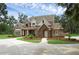 Beautiful two-story brick home with stone accents, lush landscaping, and a circular driveway at 1325 Otters View Ct, Fruitland Park, FL 34731