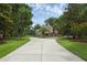 Elegant home featuring a circular driveway, mature trees, and meticulous landscaping at 1325 Otters View Ct, Fruitland Park, FL 34731