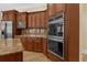Well-equipped kitchen features stainless steel appliances, wooden cabinets, and granite countertops at 1325 Otters View Ct, Fruitland Park, FL 34731