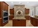 Custom kitchen boasts a stone backsplash, island, and stainless steel appliances at 1325 Otters View Ct, Fruitland Park, FL 34731