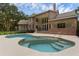 Backyard swimming pool and spa with brick home in the background at 1325 Otters View Ct, Fruitland Park, FL 34731
