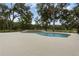 An inground swimming pool and spa with views of the lush backyard at 1325 Otters View Ct, Fruitland Park, FL 34731