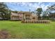 Expansive brick home featuring a large backyard, black aluminum fence, and lush green lawn at 1325 Otters View Ct, Fruitland Park, FL 34731