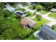 Aerial view showcases a well-maintained property with lush greenery, neighboring homes, and tree-lined streets at 1415 Braebury Dr, Leesburg, FL 34748