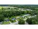 Aerial view of neighborhood surrounded by lush green trees, homes, and a lake at 1415 Braebury Dr, Leesburg, FL 34748