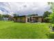 A spacious backyard featuring a covered patio and a well-maintained lawn at 1415 Braebury Dr, Leesburg, FL 34748