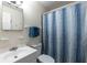 Bathroom with a standard toilet, sink, vanity, mirror, and a shower with a blue textured shower curtain at 1415 Braebury Dr, Leesburg, FL 34748