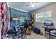 Eclectic bedroom with musical instruments, a large blue tapestry, and a window letting in natural light at 1415 Braebury Dr, Leesburg, FL 34748