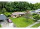 An aerial view of a home with a well-manicured lawn and mature landscaping at 1415 Braebury Dr, Leesburg, FL 34748