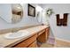 Bathroom with dual sinks, wood cabinets, and framed mirrors, offering a functional space at 1511 W Magnolia St, Clermont, FL 34711