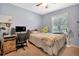 Cozy bedroom with a ceiling fan, a comfortable bed, and a study corner with a computer at 1511 W Magnolia St, Clermont, FL 34711