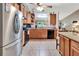 Well-lit kitchen with stainless steel refrigerator, tile floors, and a view into the living room at 1511 W Magnolia St, Clermont, FL 34711