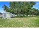 Large backyard featuring mature trees, storage shed, and a trailer in a well maintained lawn at 15629 Catherine Cir, Groveland, FL 34736
