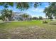 Expansive backyard featuring lush lawn, screened-in pool, and additional seating around a fire pit at 15629 Catherine Cir, Groveland, FL 34736