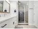 Bathroom featuring white vanity, dark hardware, and glass door shower with tile accents at 15629 Catherine Cir, Groveland, FL 34736