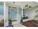 Inviting front porch with seating, potted plants, hanging flowers, and a stylish light blue front door at 15629 Catherine Cir, Groveland, FL 34736